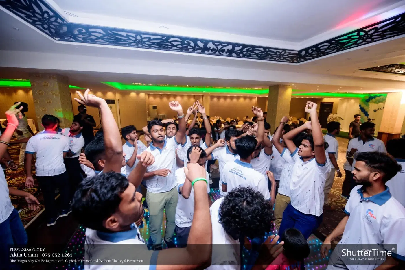 සුදු කමිස ඇඳි සිසුන් සමූහයක් අත් ඔසවා