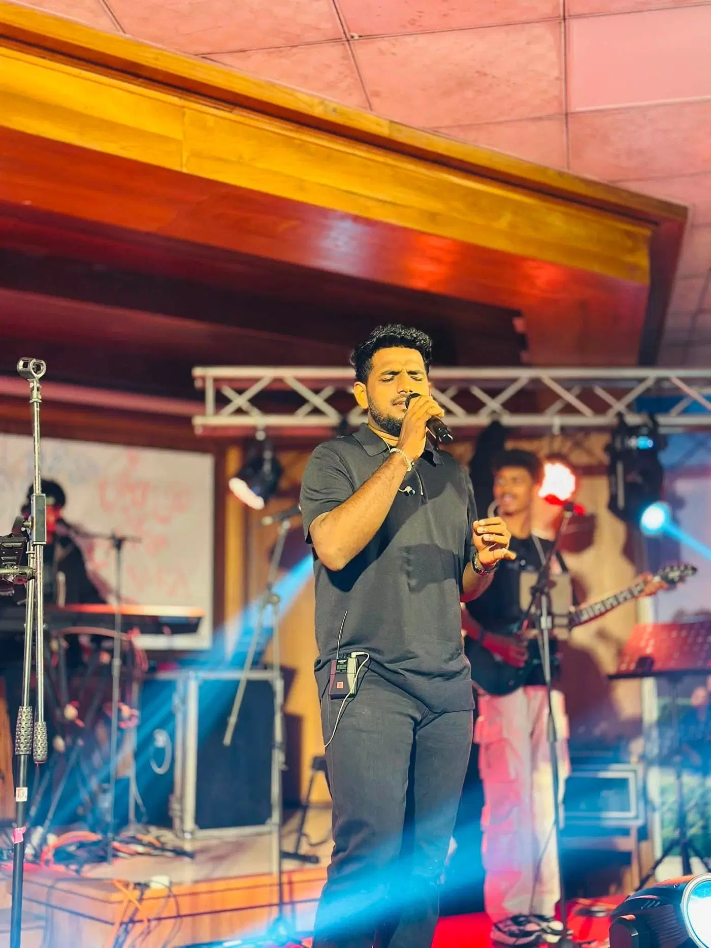 සංගීත කණ්ඩායමක් සමඟ වේදිකාවේ ගී ගයන අයෙක්