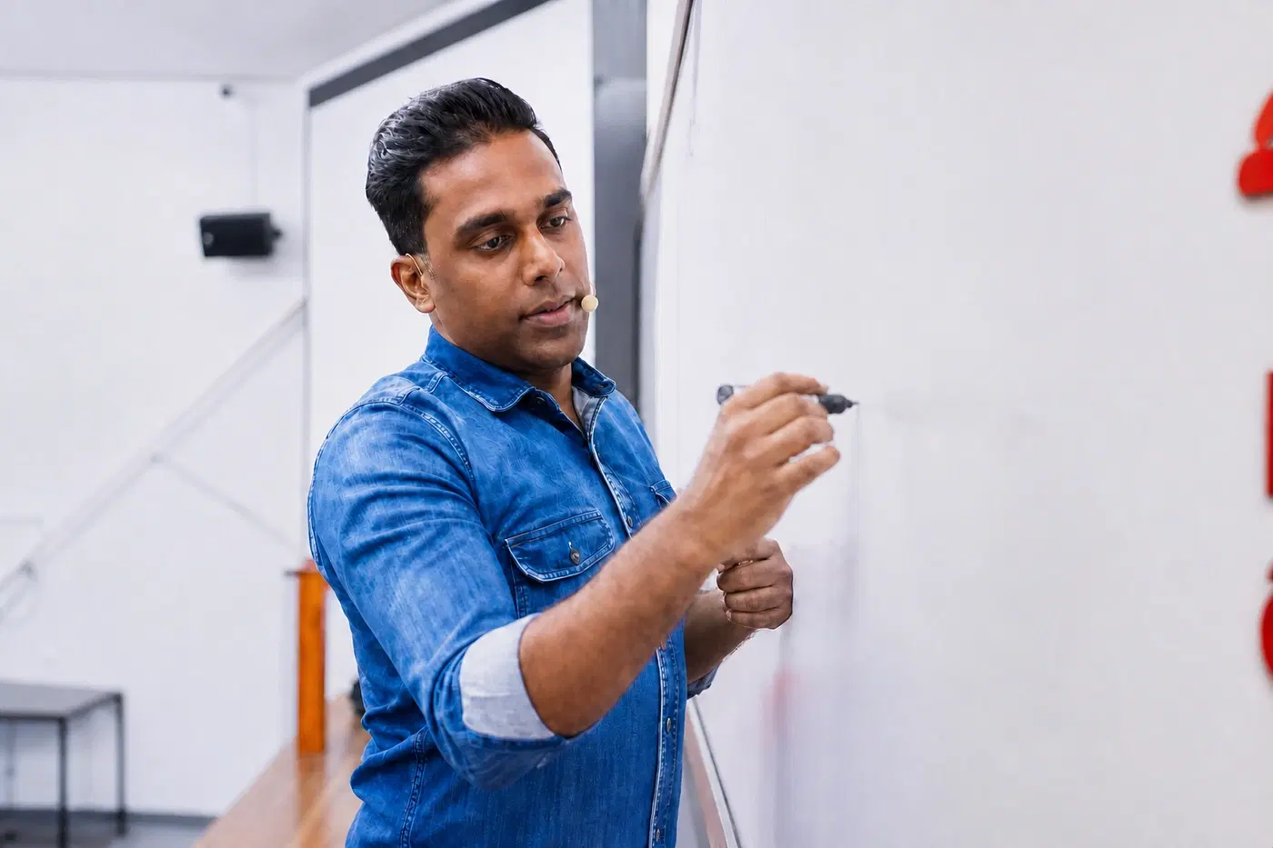 සුජිත් ලියනගේ පන්තියේ සුදු පුවරුව මත ලියමින් භෞතික විද්‍යාව උගන්වමින්